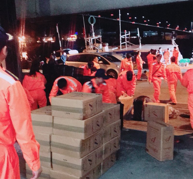 海巡署官兵從兩艘漁船上搬下14萬9000包的走私未稅洋煙