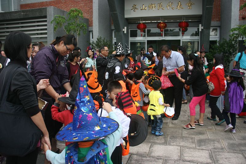 眾小鬼到達鄉代會門口，黃強呈主趕緊糖果請客