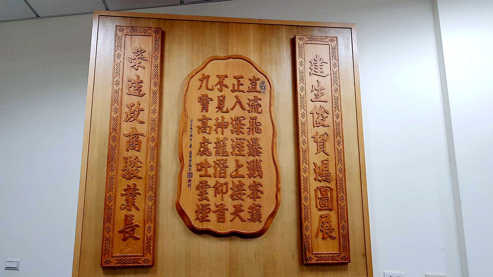 牆上掛著朋友致贈的木匾，以前議長的名字作的對聯。