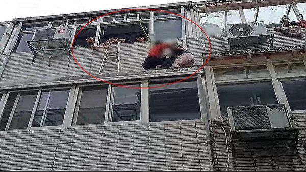 女子爬到二樓窗外雨遮處． 消防人員成功救援【影音新聞】